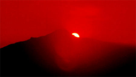 El Sol aparece por detrás del volcán La Malinche visto desde el cerro Teotón